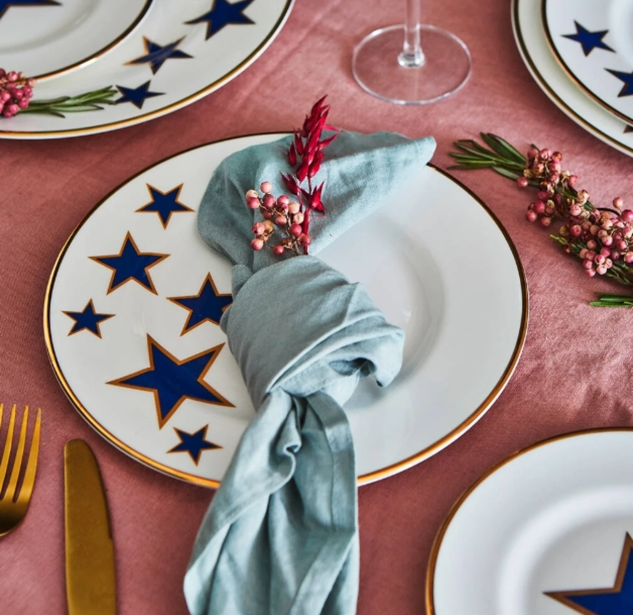 lucky stars print on a china plate with a gold rim for a christmas table arrangement