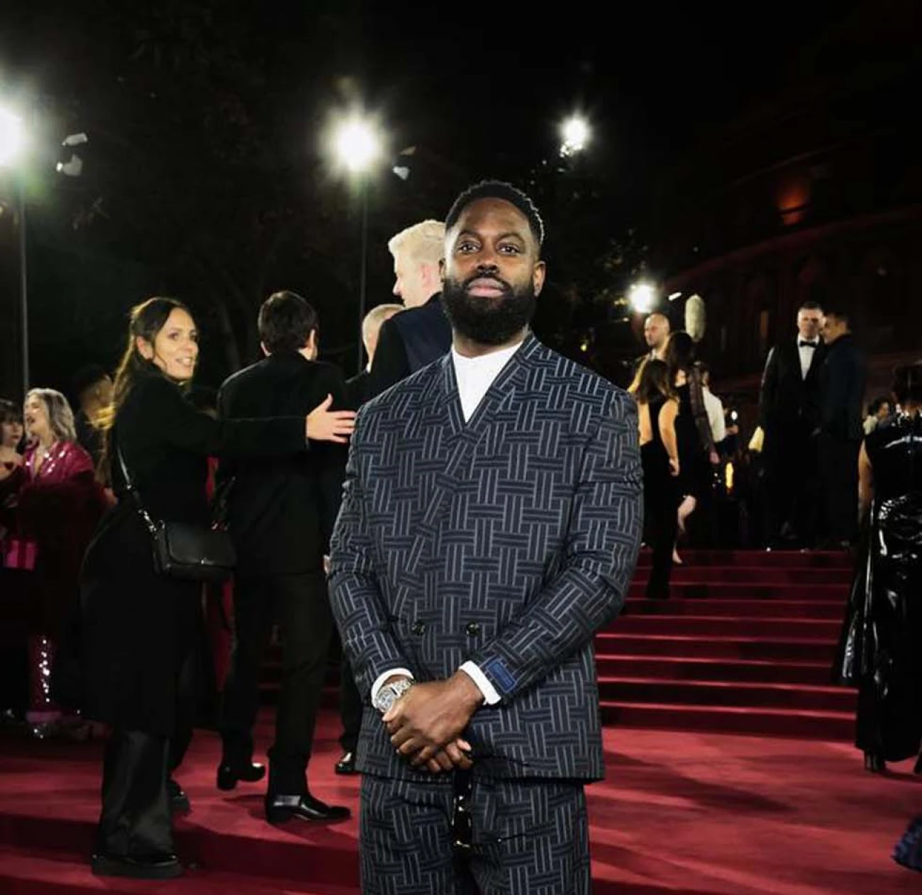 Ghetts wears a full navy Kenzo suit to the Fashion Awards 2024