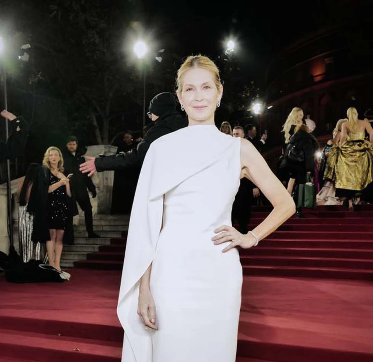 Kelly Rutherford wears a stunning white gown with an asymmetric trail