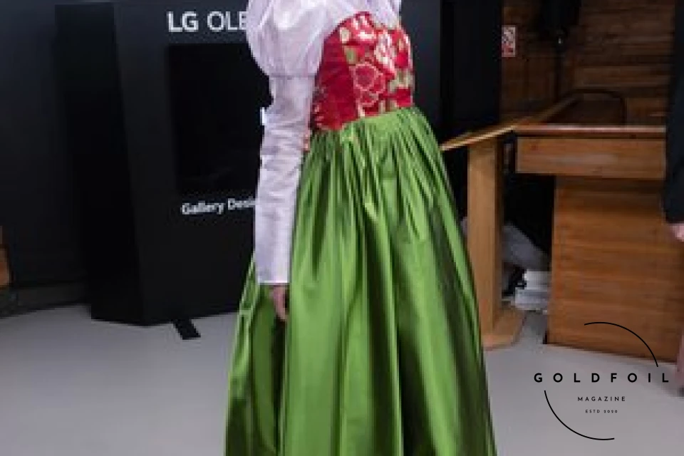 Hanbok Wave exhibiting work in the Korean Cultural Centre - Hyeon - a white top with a red corset and a bright green skirt Hanbok Wave exhibiting work in the Korean Cultural Centre - Hyeon - a white top with a red corset and a bright green skirt