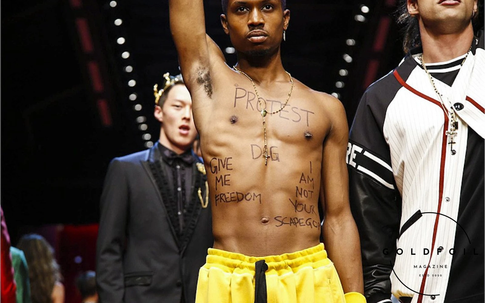 Raury - the rapper protesting against Dolce & Gabbana practices while on their catwalk by stripping shirtless in 2017. Dolce & Gabbana recently collaborated with Kim Kardashian and this is why we believe its a money grab Raury - the rapper protesting against Dolce & Gabbana practices while on their catwalk by stripping shirtless in 2017. Dolce & Gabbana recently collaborated with Kim Kardashian and this is why we believe its a money grab