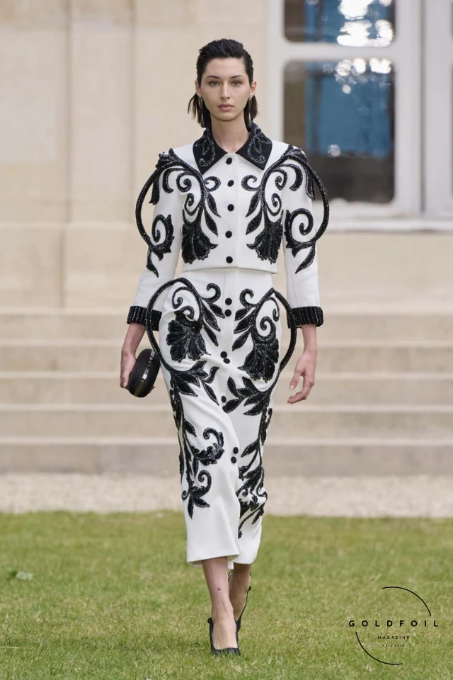 Exquisite lace cut-outs, intricate stitch work, and signature beading techniques highlighted the meticulous craftsmanship. Contrasting fabrications played with matte and shine, as well as opaque and transparent textures, adding depth and intrigue to each piece. The signature two-piece tailleur set appeared in various distinctive forms, epitomizing the brand’s exceptional savoir-faire. Exquisite lace cut-outs, intricate stitch work, and signature beading techniques highlighted the meticulous craftsmanship. Contrasting fabrications played with matte and shine, as well as opaque and transparent textures, adding depth and intrigue to each piece. The signature two-piece tailleur set appeared in various distinctive forms, epitomizing the brand’s exceptional savoir-faire.