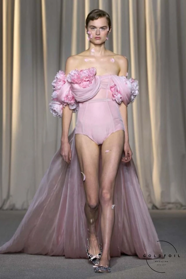 Giambattista Valli’s fall 2024 haute couture show in Paris was a vibrant spectacle, true to his signature voluminous tulle dresses while embracing an Indian influence. Held at 7 Place Vendôme, the show opened with Indian musicians and featured gowns blending Italian opulence with Indian floral motifs. Models wore bouquet-like dresses adorned with floating florals and jasmine garlands, creating a surreal mix of Valli's love for India and Botticelli-inspired paradise gardens. Giambattista Valli’s fall 2024 haute couture show in Paris was a vibrant spectacle, true to his signature voluminous tulle dresses while embracing an Indian influence. Held at 7 Place Vendôme, the show opened with Indian musicians and featured gowns blending Italian opulence with Indian floral motifs. Models wore bouquet-like dresses adorned with floating florals and jasmine garlands, creating a surreal mix of Valli's love for India and Botticelli-inspired paradise gardens.