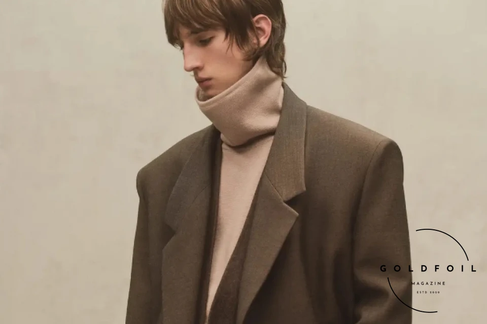 model wears a fear of god pair of tailored trousers, with a turtle neck with an interesting design in cream colour, along with a longline winter straight cut double breasted coat model wears a fear of god pair of tailored trousers, with a turtle neck with an interesting design in cream colour, along with a longline winter straight cut double breasted coat