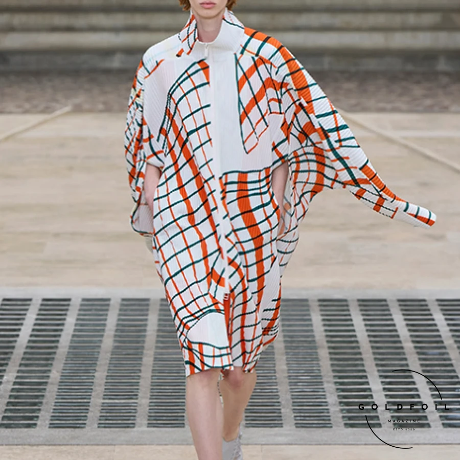 In the courtyard of the Mobilier National, Vincent de Belleval-designed slatted kites set the stage for Homme Plissé Issey Miyake's wind-inspired collection. The team took their theme seriously, reportedly even going on a parachute jump for research. Standout pieces included a pale ochre short-sleeved shirt, pant, and waistcoat with a matching tie, indicating a shift in tie trends. The collection featured dreamy wavy plaid patterns and garments with wing-like shoulders, while block-color pieces, inspired by kite construction, could be altered via buttons to sway in the breeze. In the courtyard of the Mobilier National, Vincent de Belleval-designed slatted kites set the stage for Homme Plissé Issey Miyake's wind-inspired collection. The team took their theme seriously, reportedly even going on a parachute jump for research. Standout pieces included a pale ochre short-sleeved shirt, pant, and waistcoat with a matching tie, indicating a shift in tie trends. The collection featured dreamy wavy plaid patterns and garments with wing-like shoulders, while block-color pieces, inspired by kite construction, could be altered via buttons to sway in the breeze.