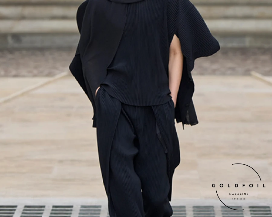 In the courtyard of the Mobilier National, Vincent de Belleval-designed slatted kites set the stage for Homme Plissé Issey Miyake's wind-inspired collection. The team took their theme seriously, reportedly even going on a parachute jump for research. Standout pieces included a pale ochre short-sleeved shirt, pant, and waistcoat with a matching tie, indicating a shift in tie trends. The collection featured dreamy wavy plaid patterns and garments with wing-like shoulders, while block-color pieces, inspired by kite construction, could be altered via buttons to sway in the breeze. In the courtyard of the Mobilier National, Vincent de Belleval-designed slatted kites set the stage for Homme Plissé Issey Miyake's wind-inspired collection. The team took their theme seriously, reportedly even going on a parachute jump for research. Standout pieces included a pale ochre short-sleeved shirt, pant, and waistcoat with a matching tie, indicating a shift in tie trends. The collection featured dreamy wavy plaid patterns and garments with wing-like shoulders, while block-color pieces, inspired by kite construction, could be altered via buttons to sway in the breeze.