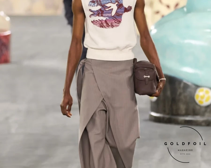 Kim Jones focused on craftsmanship and collaboration for Dior's SS25, emphasizing the skills of ateliers and artisans. Partnering with South African ceramicist Hylton Nel, Jones presented a collection celebrating work and personal expression, drawing parallels between Christian Dior, Nel, and himself. Nel's oversized cat statues adorned the runway alongside Jones' designs, which featured muted tones with vibrant accents like fluorescent vests and baby blue jackets. Nel's artwork also graced sweater vests and accessories, including a standout 70s-inspired drawstring collar, enriching the collection with artistic flair. Kim Jones focused on craftsmanship and collaboration for Dior's SS25, emphasizing the skills of ateliers and artisans. Partnering with South African ceramicist Hylton Nel, Jones presented a collection celebrating work and personal expression, drawing parallels between Christian Dior, Nel, and himself. Nel's oversized cat statues adorned the runway alongside Jones' designs, which featured muted tones with vibrant accents like fluorescent vests and baby blue jackets. Nel's artwork also graced sweater vests and accessories, including a standout 70s-inspired drawstring collar, enriching the collection with artistic flair.