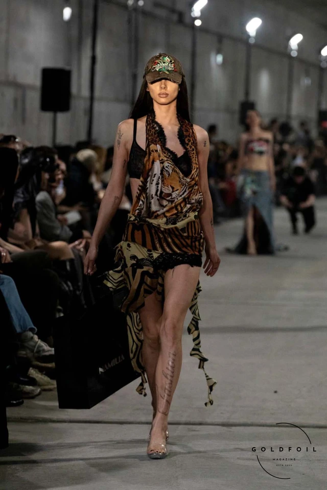 Namilia’s Spring/Summer 2025 runway show at Berlin Fashion Week was a visionary spectacle that fused futuristic design with potent social commentary. Designers Nan Li and Emilia Pfohl showcased a collection featuring high-tech fabrics, bold silhouettes, and symbolic embellishments depicting feminist icons. The use of biodegradable plastics, LED-embedded fabrics, and 3D-printed accessories highlighted the brand's commitment to sustainability, while oversized visors, holographic boots, and avant-garde jewellery added to the futuristic aesthetic. Multimedia presentations on gender equality, body positivity, and climate change underscored the show’s activist message, earning critical acclaim and reinforcing Namilia’s reputation for pushing fashion’s boundaries and inspiring change. Namilia’s Spring/Summer 2025 runway show at Berlin Fashion Week was a visionary spectacle that fused futuristic design with potent social commentary. Designers Nan Li and Emilia Pfohl showcased a collection featuring high-tech fabrics, bold silhouettes, and symbolic embellishments depicting feminist icons. The use of biodegradable plastics, LED-embedded fabrics, and 3D-printed accessories highlighted the brand's commitment to sustainability, while oversized visors, holographic boots, and avant-garde jewellery added to the futuristic aesthetic. Multimedia presentations on gender equality, body positivity, and climate change underscored the show’s activist message, earning critical acclaim and reinforcing Namilia’s reputation for pushing fashion’s boundaries and inspiring change.