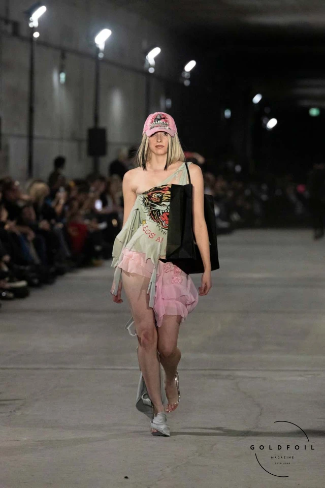 Namilia’s Spring/Summer 2025 runway show at Berlin Fashion Week was a visionary spectacle that fused futuristic design with potent social commentary. Designers Nan Li and Emilia Pfohl showcased a collection featuring high-tech fabrics, bold silhouettes, and symbolic embellishments depicting feminist icons. The use of biodegradable plastics, LED-embedded fabrics, and 3D-printed accessories highlighted the brand's commitment to sustainability, while oversized visors, holographic boots, and avant-garde jewellery added to the futuristic aesthetic. Multimedia presentations on gender equality, body positivity, and climate change underscored the show’s activist message, earning critical acclaim and reinforcing Namilia’s reputation for pushing fashion’s boundaries and inspiring change. Namilia’s Spring/Summer 2025 runway show at Berlin Fashion Week was a visionary spectacle that fused futuristic design with potent social commentary. Designers Nan Li and Emilia Pfohl showcased a collection featuring high-tech fabrics, bold silhouettes, and symbolic embellishments depicting feminist icons. The use of biodegradable plastics, LED-embedded fabrics, and 3D-printed accessories highlighted the brand's commitment to sustainability, while oversized visors, holographic boots, and avant-garde jewellery added to the futuristic aesthetic. Multimedia presentations on gender equality, body positivity, and climate change underscored the show’s activist message, earning critical acclaim and reinforcing Namilia’s reputation for pushing fashion’s boundaries and inspiring change.