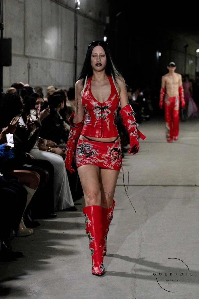 Namilia’s Spring/Summer 2025 runway show at Berlin Fashion Week was a visionary spectacle that fused futuristic design with potent social commentary. Designers Nan Li and Emilia Pfohl showcased a collection featuring high-tech fabrics, bold silhouettes, and symbolic embellishments depicting feminist icons. The use of biodegradable plastics, LED-embedded fabrics, and 3D-printed accessories highlighted the brand's commitment to sustainability, while oversized visors, holographic boots, and avant-garde jewellery added to the futuristic aesthetic. Multimedia presentations on gender equality, body positivity, and climate change underscored the show’s activist message, earning critical acclaim and reinforcing Namilia’s reputation for pushing fashion’s boundaries and inspiring change. Namilia’s Spring/Summer 2025 runway show at Berlin Fashion Week was a visionary spectacle that fused futuristic design with potent social commentary. Designers Nan Li and Emilia Pfohl showcased a collection featuring high-tech fabrics, bold silhouettes, and symbolic embellishments depicting feminist icons. The use of biodegradable plastics, LED-embedded fabrics, and 3D-printed accessories highlighted the brand's commitment to sustainability, while oversized visors, holographic boots, and avant-garde jewellery added to the futuristic aesthetic. Multimedia presentations on gender equality, body positivity, and climate change underscored the show’s activist message, earning critical acclaim and reinforcing Namilia’s reputation for pushing fashion’s boundaries and inspiring change.