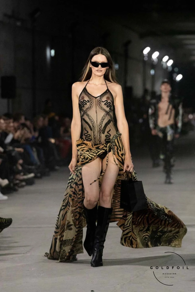 Namilia’s Spring/Summer 2025 runway show at Berlin Fashion Week was a visionary spectacle that fused futuristic design with potent social commentary. Designers Nan Li and Emilia Pfohl showcased a collection featuring high-tech fabrics, bold silhouettes, and symbolic embellishments depicting feminist icons. The use of biodegradable plastics, LED-embedded fabrics, and 3D-printed accessories highlighted the brand's commitment to sustainability, while oversized visors, holographic boots, and avant-garde jewellery added to the futuristic aesthetic. Multimedia presentations on gender equality, body positivity, and climate change underscored the show’s activist message, earning critical acclaim and reinforcing Namilia’s reputation for pushing fashion’s boundaries and inspiring change. Namilia’s Spring/Summer 2025 runway show at Berlin Fashion Week was a visionary spectacle that fused futuristic design with potent social commentary. Designers Nan Li and Emilia Pfohl showcased a collection featuring high-tech fabrics, bold silhouettes, and symbolic embellishments depicting feminist icons. The use of biodegradable plastics, LED-embedded fabrics, and 3D-printed accessories highlighted the brand's commitment to sustainability, while oversized visors, holographic boots, and avant-garde jewellery added to the futuristic aesthetic. Multimedia presentations on gender equality, body positivity, and climate change underscored the show’s activist message, earning critical acclaim and reinforcing Namilia’s reputation for pushing fashion’s boundaries and inspiring change.