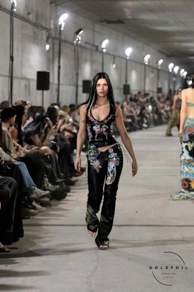 Namilia’s Spring/Summer 2025 runway show at Berlin Fashion Week was a visionary spectacle that fused futuristic design with potent social commentary. Designers Nan Li and Emilia Pfohl showcased a collection featuring high-tech fabrics, bold silhouettes, and symbolic embellishments depicting feminist icons. The use of biodegradable plastics, LED-embedded fabrics, and 3D-printed accessories highlighted the brand's commitment to sustainability, while oversized visors, holographic boots, and avant-garde jewellery added to the futuristic aesthetic. Multimedia presentations on gender equality, body positivity, and climate change underscored the show’s activist message, earning critical acclaim and reinforcing Namilia’s reputation for pushing fashion’s boundaries and inspiring change. Namilia’s Spring/Summer 2025 runway show at Berlin Fashion Week was a visionary spectacle that fused futuristic design with potent social commentary. Designers Nan Li and Emilia Pfohl showcased a collection featuring high-tech fabrics, bold silhouettes, and symbolic embellishments depicting feminist icons. The use of biodegradable plastics, LED-embedded fabrics, and 3D-printed accessories highlighted the brand's commitment to sustainability, while oversized visors, holographic boots, and avant-garde jewellery added to the futuristic aesthetic. Multimedia presentations on gender equality, body positivity, and climate change underscored the show’s activist message, earning critical acclaim and reinforcing Namilia’s reputation for pushing fashion’s boundaries and inspiring change.