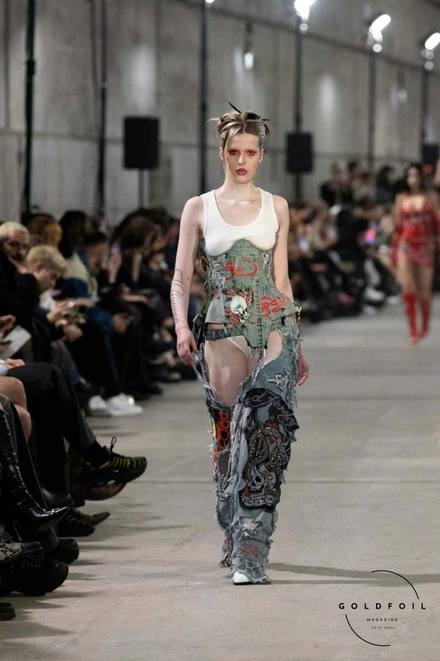 Namilia’s Spring/Summer 2025 runway show at Berlin Fashion Week was a visionary spectacle that fused futuristic design with potent social commentary. Designers Nan Li and Emilia Pfohl showcased a collection featuring high-tech fabrics, bold silhouettes, and symbolic embellishments depicting feminist icons. The use of biodegradable plastics, LED-embedded fabrics, and 3D-printed accessories highlighted the brand's commitment to sustainability, while oversized visors, holographic boots, and avant-garde jewellery added to the futuristic aesthetic. Multimedia presentations on gender equality, body positivity, and climate change underscored the show’s activist message, earning critical acclaim and reinforcing Namilia’s reputation for pushing fashion’s boundaries and inspiring change. Namilia’s Spring/Summer 2025 runway show at Berlin Fashion Week was a visionary spectacle that fused futuristic design with potent social commentary. Designers Nan Li and Emilia Pfohl showcased a collection featuring high-tech fabrics, bold silhouettes, and symbolic embellishments depicting feminist icons. The use of biodegradable plastics, LED-embedded fabrics, and 3D-printed accessories highlighted the brand's commitment to sustainability, while oversized visors, holographic boots, and avant-garde jewellery added to the futuristic aesthetic. Multimedia presentations on gender equality, body positivity, and climate change underscored the show’s activist message, earning critical acclaim and reinforcing Namilia’s reputation for pushing fashion’s boundaries and inspiring change.