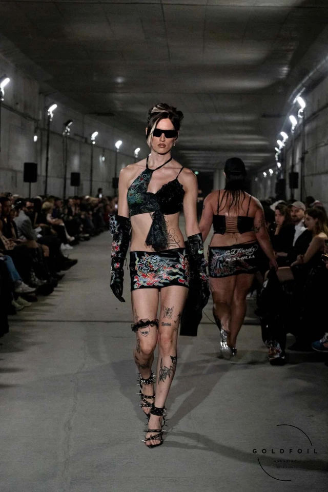 Namilia’s Spring/Summer 2025 runway show at Berlin Fashion Week was a visionary spectacle that fused futuristic design with potent social commentary. Designers Nan Li and Emilia Pfohl showcased a collection featuring high-tech fabrics, bold silhouettes, and symbolic embellishments depicting feminist icons. The use of biodegradable plastics, LED-embedded fabrics, and 3D-printed accessories highlighted the brand's commitment to sustainability, while oversized visors, holographic boots, and avant-garde jewellery added to the futuristic aesthetic. Multimedia presentations on gender equality, body positivity, and climate change underscored the show’s activist message, earning critical acclaim and reinforcing Namilia’s reputation for pushing fashion’s boundaries and inspiring change. Namilia’s Spring/Summer 2025 runway show at Berlin Fashion Week was a visionary spectacle that fused futuristic design with potent social commentary. Designers Nan Li and Emilia Pfohl showcased a collection featuring high-tech fabrics, bold silhouettes, and symbolic embellishments depicting feminist icons. The use of biodegradable plastics, LED-embedded fabrics, and 3D-printed accessories highlighted the brand's commitment to sustainability, while oversized visors, holographic boots, and avant-garde jewellery added to the futuristic aesthetic. Multimedia presentations on gender equality, body positivity, and climate change underscored the show’s activist message, earning critical acclaim and reinforcing Namilia’s reputation for pushing fashion’s boundaries and inspiring change.