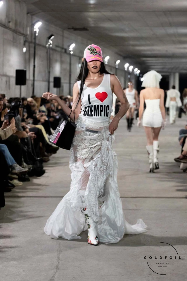 Namilia’s Spring/Summer 2025 runway show at Berlin Fashion Week was a visionary spectacle that fused futuristic design with potent social commentary. Designers Nan Li and Emilia Pfohl showcased a collection featuring high-tech fabrics, bold silhouettes, and symbolic embellishments depicting feminist icons. The use of biodegradable plastics, LED-embedded fabrics, and 3D-printed accessories highlighted the brand's commitment to sustainability, while oversized visors, holographic boots, and avant-garde jewellery added to the futuristic aesthetic. Multimedia presentations on gender equality, body positivity, and climate change underscored the show’s activist message, earning critical acclaim and reinforcing Namilia’s reputation for pushing fashion’s boundaries and inspiring change. Namilia’s Spring/Summer 2025 runway show at Berlin Fashion Week was a visionary spectacle that fused futuristic design with potent social commentary. Designers Nan Li and Emilia Pfohl showcased a collection featuring high-tech fabrics, bold silhouettes, and symbolic embellishments depicting feminist icons. The use of biodegradable plastics, LED-embedded fabrics, and 3D-printed accessories highlighted the brand's commitment to sustainability, while oversized visors, holographic boots, and avant-garde jewellery added to the futuristic aesthetic. Multimedia presentations on gender equality, body positivity, and climate change underscored the show’s activist message, earning critical acclaim and reinforcing Namilia’s reputation for pushing fashion’s boundaries and inspiring change.