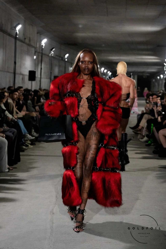 Namilia’s Spring/Summer 2025 runway show at Berlin Fashion Week was a visionary spectacle that fused futuristic design with potent social commentary. Designers Nan Li and Emilia Pfohl showcased a collection featuring high-tech fabrics, bold silhouettes, and symbolic embellishments depicting feminist icons. The use of biodegradable plastics, LED-embedded fabrics, and 3D-printed accessories highlighted the brand's commitment to sustainability, while oversized visors, holographic boots, and avant-garde jewellery added to the futuristic aesthetic. Multimedia presentations on gender equality, body positivity, and climate change underscored the show’s activist message, earning critical acclaim and reinforcing Namilia’s reputation for pushing fashion’s boundaries and inspiring change. Namilia’s Spring/Summer 2025 runway show at Berlin Fashion Week was a visionary spectacle that fused futuristic design with potent social commentary. Designers Nan Li and Emilia Pfohl showcased a collection featuring high-tech fabrics, bold silhouettes, and symbolic embellishments depicting feminist icons. The use of biodegradable plastics, LED-embedded fabrics, and 3D-printed accessories highlighted the brand's commitment to sustainability, while oversized visors, holographic boots, and avant-garde jewellery added to the futuristic aesthetic. Multimedia presentations on gender equality, body positivity, and climate change underscored the show’s activist message, earning critical acclaim and reinforcing Namilia’s reputation for pushing fashion’s boundaries and inspiring change.