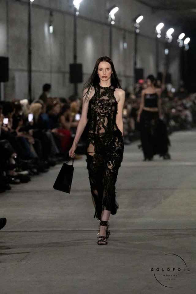 Namilia’s Spring/Summer 2025 runway show at Berlin Fashion Week was a visionary spectacle that fused futuristic design with potent social commentary. Designers Nan Li and Emilia Pfohl showcased a collection featuring high-tech fabrics, bold silhouettes, and symbolic embellishments depicting feminist icons. The use of biodegradable plastics, LED-embedded fabrics, and 3D-printed accessories highlighted the brand's commitment to sustainability, while oversized visors, holographic boots, and avant-garde jewellery added to the futuristic aesthetic. Multimedia presentations on gender equality, body positivity, and climate change underscored the show’s activist message, earning critical acclaim and reinforcing Namilia’s reputation for pushing fashion’s boundaries and inspiring change. Namilia’s Spring/Summer 2025 runway show at Berlin Fashion Week was a visionary spectacle that fused futuristic design with potent social commentary. Designers Nan Li and Emilia Pfohl showcased a collection featuring high-tech fabrics, bold silhouettes, and symbolic embellishments depicting feminist icons. The use of biodegradable plastics, LED-embedded fabrics, and 3D-printed accessories highlighted the brand's commitment to sustainability, while oversized visors, holographic boots, and avant-garde jewellery added to the futuristic aesthetic. Multimedia presentations on gender equality, body positivity, and climate change underscored the show’s activist message, earning critical acclaim and reinforcing Namilia’s reputation for pushing fashion’s boundaries and inspiring change.