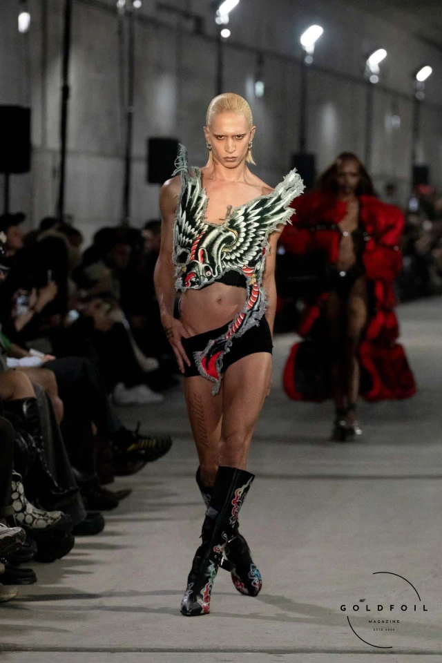 Namilia’s Spring/Summer 2025 runway show at Berlin Fashion Week was a visionary spectacle that fused futuristic design with potent social commentary. Designers Nan Li and Emilia Pfohl showcased a collection featuring high-tech fabrics, bold silhouettes, and symbolic embellishments depicting feminist icons. The use of biodegradable plastics, LED-embedded fabrics, and 3D-printed accessories highlighted the brand's commitment to sustainability, while oversized visors, holographic boots, and avant-garde jewellery added to the futuristic aesthetic. Multimedia presentations on gender equality, body positivity, and climate change underscored the show’s activist message, earning critical acclaim and reinforcing Namilia’s reputation for pushing fashion’s boundaries and inspiring change. Namilia’s Spring/Summer 2025 runway show at Berlin Fashion Week was a visionary spectacle that fused futuristic design with potent social commentary. Designers Nan Li and Emilia Pfohl showcased a collection featuring high-tech fabrics, bold silhouettes, and symbolic embellishments depicting feminist icons. The use of biodegradable plastics, LED-embedded fabrics, and 3D-printed accessories highlighted the brand's commitment to sustainability, while oversized visors, holographic boots, and avant-garde jewellery added to the futuristic aesthetic. Multimedia presentations on gender equality, body positivity, and climate change underscored the show’s activist message, earning critical acclaim and reinforcing Namilia’s reputation for pushing fashion’s boundaries and inspiring change.