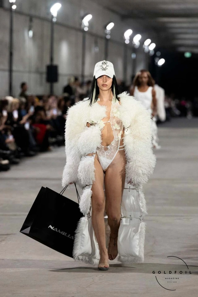 Namilia’s Spring/Summer 2025 runway show at Berlin Fashion Week was a visionary spectacle that fused futuristic design with potent social commentary. Designers Nan Li and Emilia Pfohl showcased a collection featuring high-tech fabrics, bold silhouettes, and symbolic embellishments depicting feminist icons. The use of biodegradable plastics, LED-embedded fabrics, and 3D-printed accessories highlighted the brand's commitment to sustainability, while oversized visors, holographic boots, and avant-garde jewellery added to the futuristic aesthetic. Multimedia presentations on gender equality, body positivity, and climate change underscored the show’s activist message, earning critical acclaim and reinforcing Namilia’s reputation for pushing fashion’s boundaries and inspiring change. Namilia’s Spring/Summer 2025 runway show at Berlin Fashion Week was a visionary spectacle that fused futuristic design with potent social commentary. Designers Nan Li and Emilia Pfohl showcased a collection featuring high-tech fabrics, bold silhouettes, and symbolic embellishments depicting feminist icons. The use of biodegradable plastics, LED-embedded fabrics, and 3D-printed accessories highlighted the brand's commitment to sustainability, while oversized visors, holographic boots, and avant-garde jewellery added to the futuristic aesthetic. Multimedia presentations on gender equality, body positivity, and climate change underscored the show’s activist message, earning critical acclaim and reinforcing Namilia’s reputation for pushing fashion’s boundaries and inspiring change.