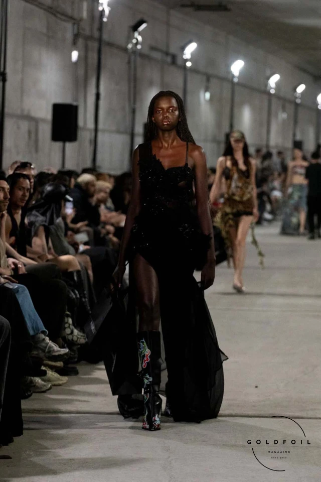 Namilia’s Spring/Summer 2025 runway show at Berlin Fashion Week was a visionary spectacle that fused futuristic design with potent social commentary. Designers Nan Li and Emilia Pfohl showcased a collection featuring high-tech fabrics, bold silhouettes, and symbolic embellishments depicting feminist icons. The use of biodegradable plastics, LED-embedded fabrics, and 3D-printed accessories highlighted the brand's commitment to sustainability, while oversized visors, holographic boots, and avant-garde jewellery added to the futuristic aesthetic. Multimedia presentations on gender equality, body positivity, and climate change underscored the show’s activist message, earning critical acclaim and reinforcing Namilia’s reputation for pushing fashion’s boundaries and inspiring change. Namilia’s Spring/Summer 2025 runway show at Berlin Fashion Week was a visionary spectacle that fused futuristic design with potent social commentary. Designers Nan Li and Emilia Pfohl showcased a collection featuring high-tech fabrics, bold silhouettes, and symbolic embellishments depicting feminist icons. The use of biodegradable plastics, LED-embedded fabrics, and 3D-printed accessories highlighted the brand's commitment to sustainability, while oversized visors, holographic boots, and avant-garde jewellery added to the futuristic aesthetic. Multimedia presentations on gender equality, body positivity, and climate change underscored the show’s activist message, earning critical acclaim and reinforcing Namilia’s reputation for pushing fashion’s boundaries and inspiring change.