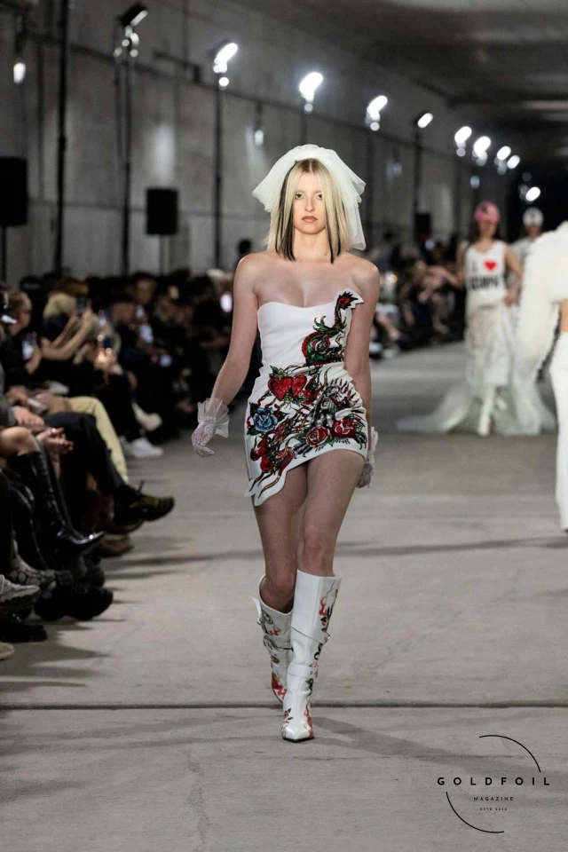 Namilia’s Spring/Summer 2025 runway show at Berlin Fashion Week was a visionary spectacle that fused futuristic design with potent social commentary. Designers Nan Li and Emilia Pfohl showcased a collection featuring high-tech fabrics, bold silhouettes, and symbolic embellishments depicting feminist icons. The use of biodegradable plastics, LED-embedded fabrics, and 3D-printed accessories highlighted the brand's commitment to sustainability, while oversized visors, holographic boots, and avant-garde jewellery added to the futuristic aesthetic. Multimedia presentations on gender equality, body positivity, and climate change underscored the show’s activist message, earning critical acclaim and reinforcing Namilia’s reputation for pushing fashion’s boundaries and inspiring change. Namilia’s Spring/Summer 2025 runway show at Berlin Fashion Week was a visionary spectacle that fused futuristic design with potent social commentary. Designers Nan Li and Emilia Pfohl showcased a collection featuring high-tech fabrics, bold silhouettes, and symbolic embellishments depicting feminist icons. The use of biodegradable plastics, LED-embedded fabrics, and 3D-printed accessories highlighted the brand's commitment to sustainability, while oversized visors, holographic boots, and avant-garde jewellery added to the futuristic aesthetic. Multimedia presentations on gender equality, body positivity, and climate change underscored the show’s activist message, earning critical acclaim and reinforcing Namilia’s reputation for pushing fashion’s boundaries and inspiring change.