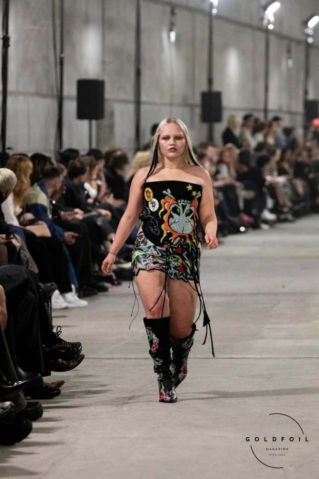 Namilia’s Spring/Summer 2025 runway show at Berlin Fashion Week was a visionary spectacle that fused futuristic design with potent social commentary. Designers Nan Li and Emilia Pfohl showcased a collection featuring high-tech fabrics, bold silhouettes, and symbolic embellishments depicting feminist icons. The use of biodegradable plastics, LED-embedded fabrics, and 3D-printed accessories highlighted the brand's commitment to sustainability, while oversized visors, holographic boots, and avant-garde jewellery added to the futuristic aesthetic. Multimedia presentations on gender equality, body positivity, and climate change underscored the show’s activist message, earning critical acclaim and reinforcing Namilia’s reputation for pushing fashion’s boundaries and inspiring change. Namilia’s Spring/Summer 2025 runway show at Berlin Fashion Week was a visionary spectacle that fused futuristic design with potent social commentary. Designers Nan Li and Emilia Pfohl showcased a collection featuring high-tech fabrics, bold silhouettes, and symbolic embellishments depicting feminist icons. The use of biodegradable plastics, LED-embedded fabrics, and 3D-printed accessories highlighted the brand's commitment to sustainability, while oversized visors, holographic boots, and avant-garde jewellery added to the futuristic aesthetic. Multimedia presentations on gender equality, body positivity, and climate change underscored the show’s activist message, earning critical acclaim and reinforcing Namilia’s reputation for pushing fashion’s boundaries and inspiring change.