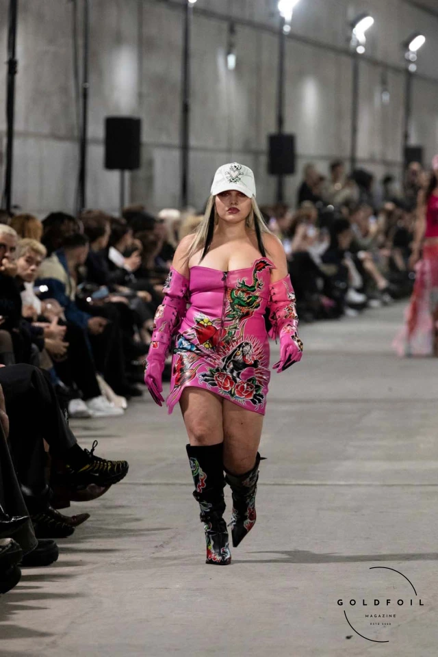 Namilia’s Spring/Summer 2025 runway show at Berlin Fashion Week was a visionary spectacle that fused futuristic design with potent social commentary. Designers Nan Li and Emilia Pfohl showcased a collection featuring high-tech fabrics, bold silhouettes, and symbolic embellishments depicting feminist icons. The use of biodegradable plastics, LED-embedded fabrics, and 3D-printed accessories highlighted the brand's commitment to sustainability, while oversized visors, holographic boots, and avant-garde jewellery added to the futuristic aesthetic. Multimedia presentations on gender equality, body positivity, and climate change underscored the show’s activist message, earning critical acclaim and reinforcing Namilia’s reputation for pushing fashion’s boundaries and inspiring change. Namilia’s Spring/Summer 2025 runway show at Berlin Fashion Week was a visionary spectacle that fused futuristic design with potent social commentary. Designers Nan Li and Emilia Pfohl showcased a collection featuring high-tech fabrics, bold silhouettes, and symbolic embellishments depicting feminist icons. The use of biodegradable plastics, LED-embedded fabrics, and 3D-printed accessories highlighted the brand's commitment to sustainability, while oversized visors, holographic boots, and avant-garde jewellery added to the futuristic aesthetic. Multimedia presentations on gender equality, body positivity, and climate change underscored the show’s activist message, earning critical acclaim and reinforcing Namilia’s reputation for pushing fashion’s boundaries and inspiring change.