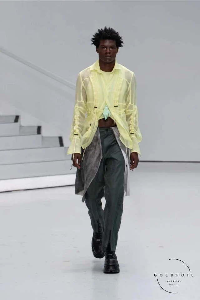 Yenesai’s latest collection, inspired by the desert biome, offers innovative solutions and challenges through color theory, soft fabrics, refined basics, and explorative accessories tailored for the future nomad. Emphasizing functionality, the collection includes garments that facilitate movement and action, while incorporating harvested resources like crystals and essential oils in their new clear resin canister bag. Advances in 3D-printed accessories, including a cyborg hand clasp and redesigned eyewear, reflect the nomad’s evolving relationship with the environment, showcased in shiny, flecked fabrics and gemstone-inspired textures. The show concludes with leather looks featuring intricate paneling and armor-style layering. Yenesai, named after the Yenesai River, blends futuristic vision with ancestral nomadic values, offering technical fabrics and striking silhouettes for a global community of travelers, and fostering creative collaboration through retreats and events. Yenesai’s latest collection, inspired by the desert biome, offers innovative solutions and challenges through color theory, soft fabrics, refined basics, and explorative accessories tailored for the future nomad. Emphasizing functionality, the collection includes garments that facilitate movement and action, while incorporating harvested resources like crystals and essential oils in their new clear resin canister bag. Advances in 3D-printed accessories, including a cyborg hand clasp and redesigned eyewear, reflect the nomad’s evolving relationship with the environment, showcased in shiny, flecked fabrics and gemstone-inspired textures. The show concludes with leather looks featuring intricate paneling and armor-style layering. Yenesai, named after the Yenesai River, blends futuristic vision with ancestral nomadic values, offering technical fabrics and striking silhouettes for a global community of travelers, and fostering creative collaboration through retreats and events.