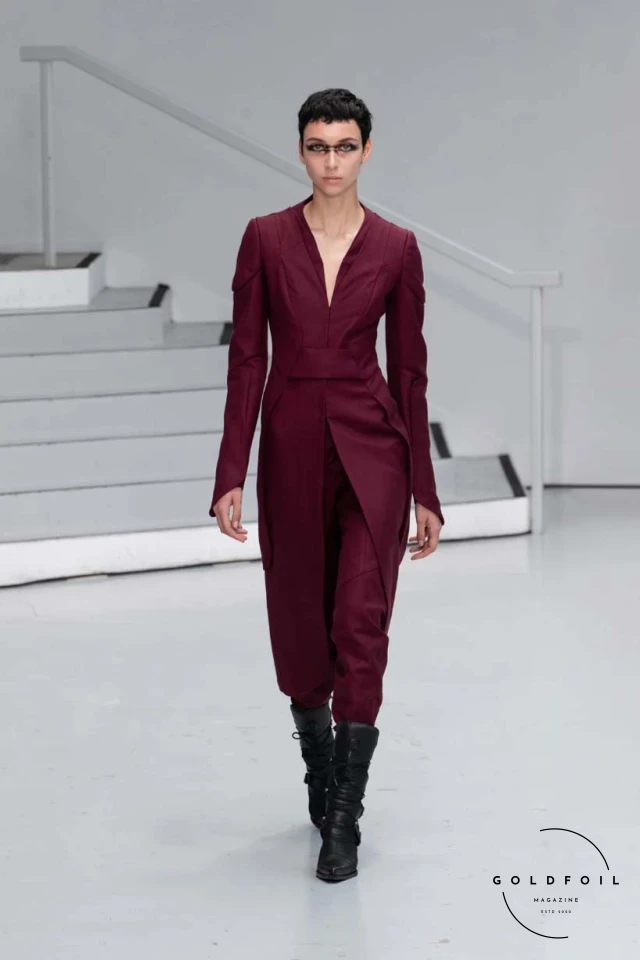 Yenesai’s latest collection, inspired by the desert biome, offers innovative solutions and challenges through color theory, soft fabrics, refined basics, and explorative accessories tailored for the future nomad. Emphasizing functionality, the collection includes garments that facilitate movement and action, while incorporating harvested resources like crystals and essential oils in their new clear resin canister bag. Advances in 3D-printed accessories, including a cyborg hand clasp and redesigned eyewear, reflect the nomad’s evolving relationship with the environment, showcased in shiny, flecked fabrics and gemstone-inspired textures. The show concludes with leather looks featuring intricate paneling and armor-style layering. Yenesai, named after the Yenesai River, blends futuristic vision with ancestral nomadic values, offering technical fabrics and striking silhouettes for a global community of travelers, and fostering creative collaboration through retreats and events. Yenesai’s latest collection, inspired by the desert biome, offers innovative solutions and challenges through color theory, soft fabrics, refined basics, and explorative accessories tailored for the future nomad. Emphasizing functionality, the collection includes garments that facilitate movement and action, while incorporating harvested resources like crystals and essential oils in their new clear resin canister bag. Advances in 3D-printed accessories, including a cyborg hand clasp and redesigned eyewear, reflect the nomad’s evolving relationship with the environment, showcased in shiny, flecked fabrics and gemstone-inspired textures. The show concludes with leather looks featuring intricate paneling and armor-style layering. Yenesai, named after the Yenesai River, blends futuristic vision with ancestral nomadic values, offering technical fabrics and striking silhouettes for a global community of travelers, and fostering creative collaboration through retreats and events.