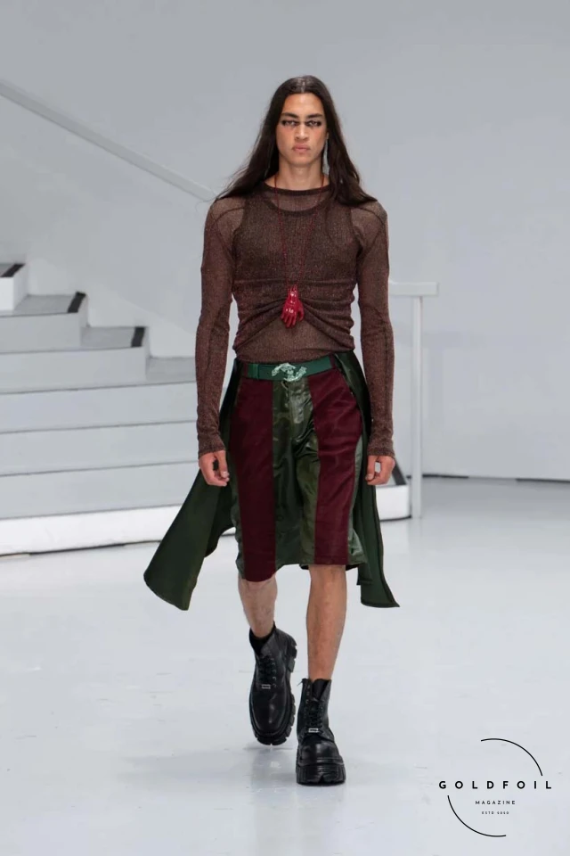 Yenesai’s latest collection, inspired by the desert biome, offers innovative solutions and challenges through color theory, soft fabrics, refined basics, and explorative accessories tailored for the future nomad. Emphasizing functionality, the collection includes garments that facilitate movement and action, while incorporating harvested resources like crystals and essential oils in their new clear resin canister bag. Advances in 3D-printed accessories, including a cyborg hand clasp and redesigned eyewear, reflect the nomad’s evolving relationship with the environment, showcased in shiny, flecked fabrics and gemstone-inspired textures. The show concludes with leather looks featuring intricate paneling and armor-style layering. Yenesai, named after the Yenesai River, blends futuristic vision with ancestral nomadic values, offering technical fabrics and striking silhouettes for a global community of travelers, and fostering creative collaboration through retreats and events. Yenesai’s latest collection, inspired by the desert biome, offers innovative solutions and challenges through color theory, soft fabrics, refined basics, and explorative accessories tailored for the future nomad. Emphasizing functionality, the collection includes garments that facilitate movement and action, while incorporating harvested resources like crystals and essential oils in their new clear resin canister bag. Advances in 3D-printed accessories, including a cyborg hand clasp and redesigned eyewear, reflect the nomad’s evolving relationship with the environment, showcased in shiny, flecked fabrics and gemstone-inspired textures. The show concludes with leather looks featuring intricate paneling and armor-style layering. Yenesai, named after the Yenesai River, blends futuristic vision with ancestral nomadic values, offering technical fabrics and striking silhouettes for a global community of travelers, and fostering creative collaboration through retreats and events.