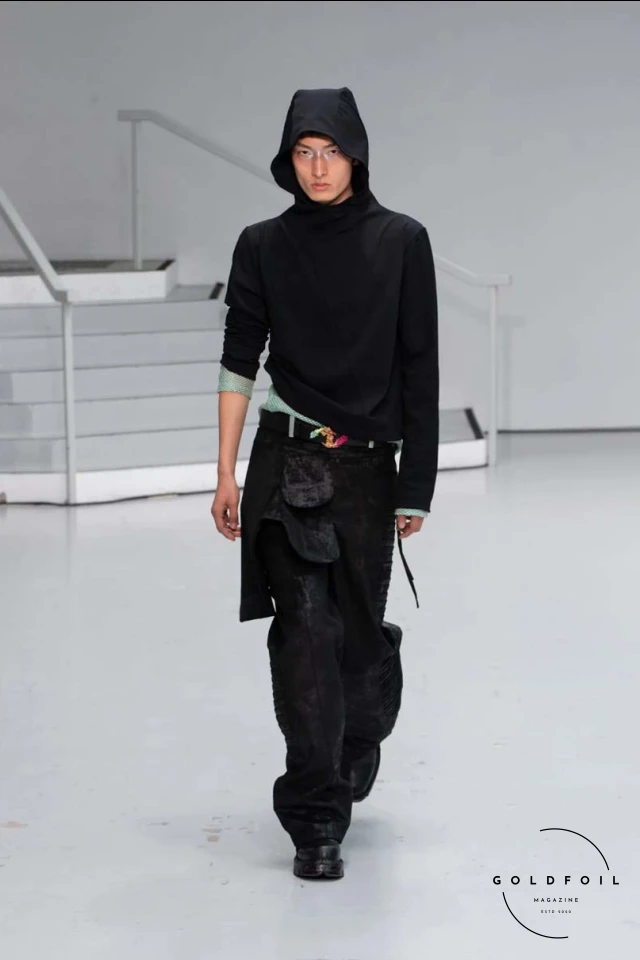 Yenesai’s latest collection, inspired by the desert biome, offers innovative solutions and challenges through color theory, soft fabrics, refined basics, and explorative accessories tailored for the future nomad. Emphasizing functionality, the collection includes garments that facilitate movement and action, while incorporating harvested resources like crystals and essential oils in their new clear resin canister bag. Advances in 3D-printed accessories, including a cyborg hand clasp and redesigned eyewear, reflect the nomad’s evolving relationship with the environment, showcased in shiny, flecked fabrics and gemstone-inspired textures. The show concludes with leather looks featuring intricate paneling and armor-style layering. Yenesai, named after the Yenesai River, blends futuristic vision with ancestral nomadic values, offering technical fabrics and striking silhouettes for a global community of travelers, and fostering creative collaboration through retreats and events. Yenesai’s latest collection, inspired by the desert biome, offers innovative solutions and challenges through color theory, soft fabrics, refined basics, and explorative accessories tailored for the future nomad. Emphasizing functionality, the collection includes garments that facilitate movement and action, while incorporating harvested resources like crystals and essential oils in their new clear resin canister bag. Advances in 3D-printed accessories, including a cyborg hand clasp and redesigned eyewear, reflect the nomad’s evolving relationship with the environment, showcased in shiny, flecked fabrics and gemstone-inspired textures. The show concludes with leather looks featuring intricate paneling and armor-style layering. Yenesai, named after the Yenesai River, blends futuristic vision with ancestral nomadic values, offering technical fabrics and striking silhouettes for a global community of travelers, and fostering creative collaboration through retreats and events.