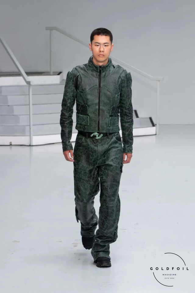 Yenesai’s latest collection, inspired by the desert biome, offers innovative solutions and challenges through color theory, soft fabrics, refined basics, and explorative accessories tailored for the future nomad. Emphasizing functionality, the collection includes garments that facilitate movement and action, while incorporating harvested resources like crystals and essential oils in their new clear resin canister bag. Advances in 3D-printed accessories, including a cyborg hand clasp and redesigned eyewear, reflect the nomad’s evolving relationship with the environment, showcased in shiny, flecked fabrics and gemstone-inspired textures. The show concludes with leather looks featuring intricate paneling and armor-style layering. Yenesai, named after the Yenesai River, blends futuristic vision with ancestral nomadic values, offering technical fabrics and striking silhouettes for a global community of travelers, and fostering creative collaboration through retreats and events. Yenesai’s latest collection, inspired by the desert biome, offers innovative solutions and challenges through color theory, soft fabrics, refined basics, and explorative accessories tailored for the future nomad. Emphasizing functionality, the collection includes garments that facilitate movement and action, while incorporating harvested resources like crystals and essential oils in their new clear resin canister bag. Advances in 3D-printed accessories, including a cyborg hand clasp and redesigned eyewear, reflect the nomad’s evolving relationship with the environment, showcased in shiny, flecked fabrics and gemstone-inspired textures. The show concludes with leather looks featuring intricate paneling and armor-style layering. Yenesai, named after the Yenesai River, blends futuristic vision with ancestral nomadic values, offering technical fabrics and striking silhouettes for a global community of travelers, and fostering creative collaboration through retreats and events.