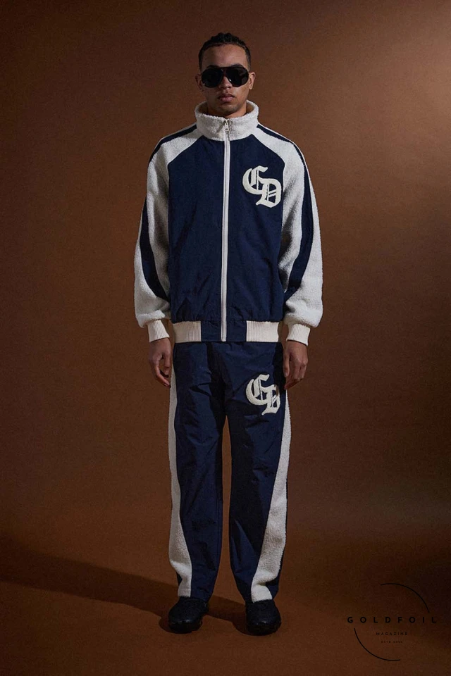 A model wears a tracksuit in blue and white. Criminal Damage, London's iconic streetwear brand established in 1991, redefines the fashion landscape with its FW24  A model wears a tracksuit in blue and white. Criminal Damage, London's iconic streetwear brand established in 1991, redefines the fashion landscape with its FW24