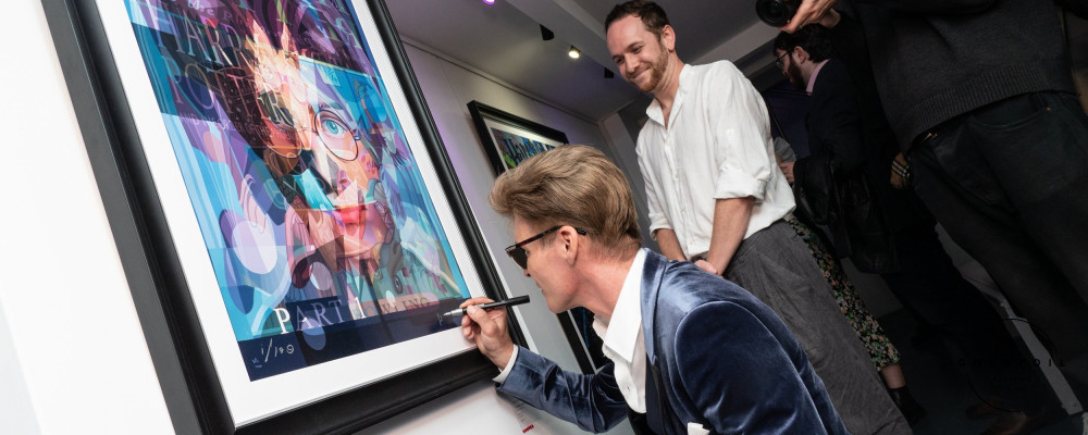 Stuart McAlpine Miller signing one of his artworks inspired by the Harry Potter series