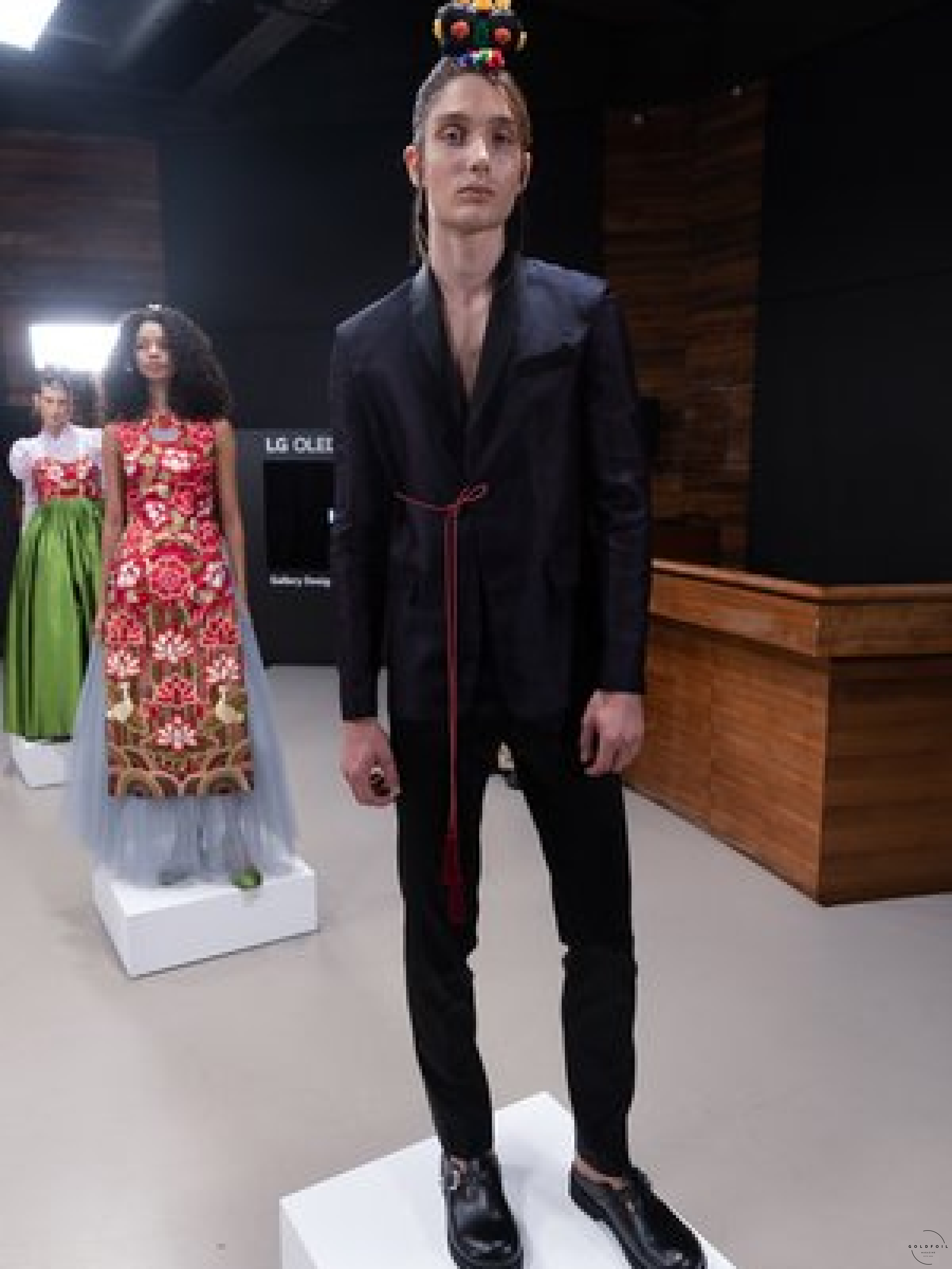 Hanbok Wave exhibiting work in the Korean Cultural Centre - Hyeon - a full black outfit with a blazer, polished leather shoes and tailored trousers