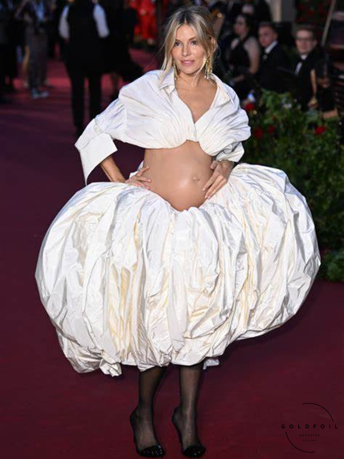 Sienna Miller for Vogue World in London, wearing a custom Schiaparelli two piece outfit, a balloon skirt and a top showing off a cute baby bump