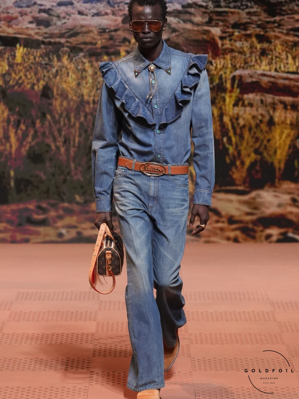 A model walking for Louis Vuitton wearing a double denim outfit